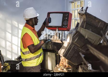 Mark Oluoch an electronic waste worker with Waste Electrical and Electronic Equipment Centre (WEEE Centre) sorts electronic waste at an e-waste collection center in Nakuru before it is later transported to Nairobi for recycling. Kenya generates about 11,000 metric tonnes of electronic waste every year, most of this waste has been found to contain harmful chemicals like lead, mercury, and phosphorus. There are calls to increase collection and recycling rates for both electronic and plastic waste to safeguard the environment and public health. Stock Photo