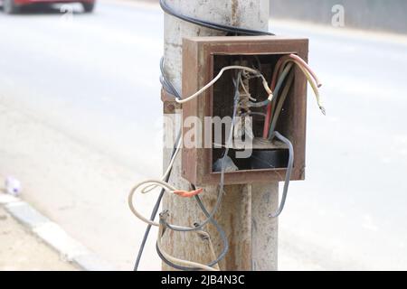 Electric fuse box with broken wires or abandoned switch box on a streetlight Stock Photo