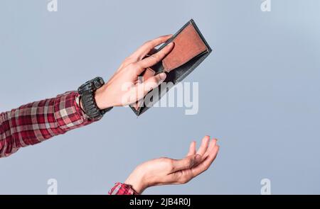 Concept of an empty wallet, hand opening empty wallet on isolated background, concept of economic crisis Stock Photo