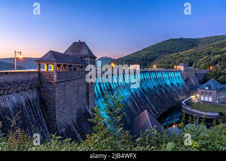 Dam in evening light, bright cyan illuminated, dam wall of Edersee reservoir, Hemfurth power station, Edertal dam, Eder dam, Waldeck Castle and Hotel Stock Photo