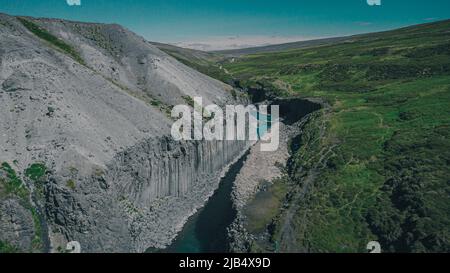 Aerial drone panorama of studlagil canyon in Iceland, picturesque valley with basalt columns standing high on a warm summer day. Stock Photo