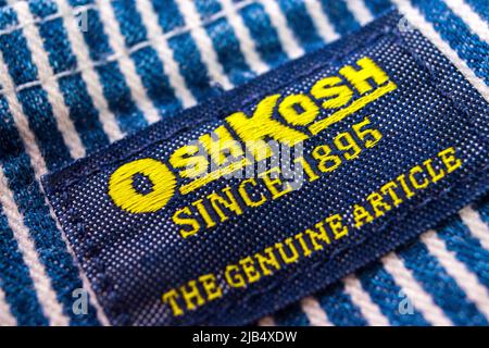 The brand tag of OshKosh on its hickory striped overalls. OshKosh B ...