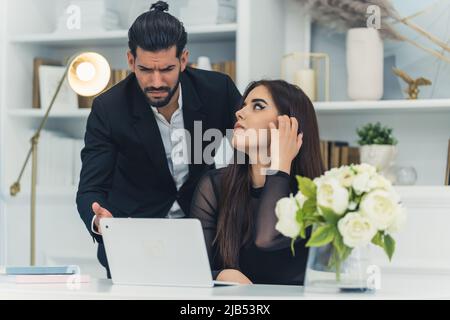 Mad bearded middle-aged boss yells at his female worker. Not helpful male boss devastated after seeing sales results. Office interior. High quality photo Stock Photo