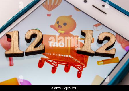 Kumamoto, JAPAN - Dec 10 2020 : Taobao logo with wooden numbers “double 12” on iPhone. Double twelve (W12) is the Chinese version of Black Friday Stock Photo