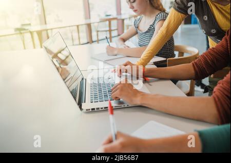 Crop students doing homework together Stock Photo
