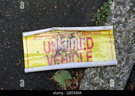 british untaxed vehicle sticker on the ground having been removed from a vehicle despite warning not to remove, twickenham, middlesex, england Stock Photo