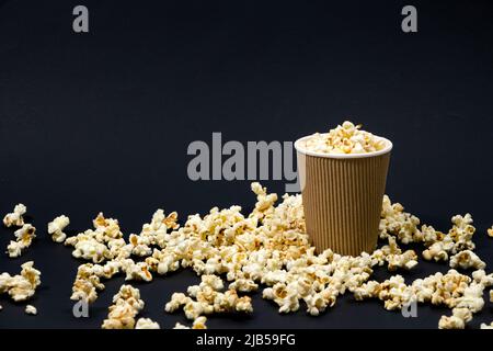 Popcorn in a glass on a black background with space for text. Stock Photo