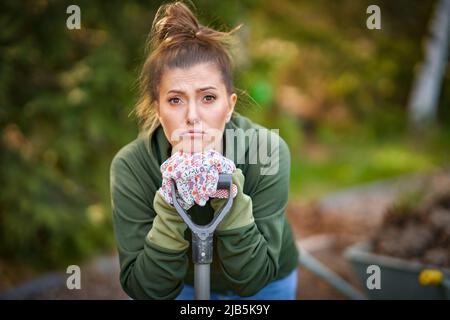 Picture of tired woman working with tools in the garden Stock Photo