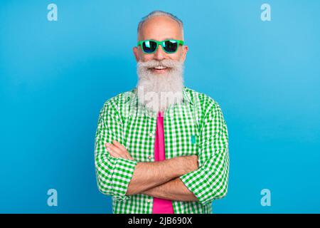 Photo of cheerful satisfied granddad crossed arms beaming smile isolated on blue color background Stock Photo