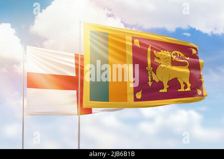 Sunny blue sky and flags of sri lanka and england Stock Photo