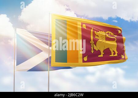 Sunny blue sky and flags of sri lanka and scotland Stock Photo