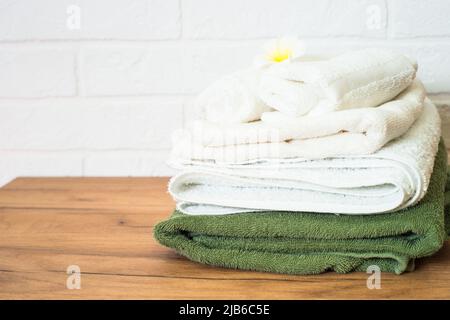 Bottle of soap and stack of towels in white bathroom. Stock Photo