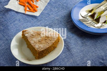 Closeup,top view of slice of fresh Carrot Cake with Icing Sugar sprinkled on top placed, on dark blue background.Healthy,moist Christmas  cake. Stock Photo