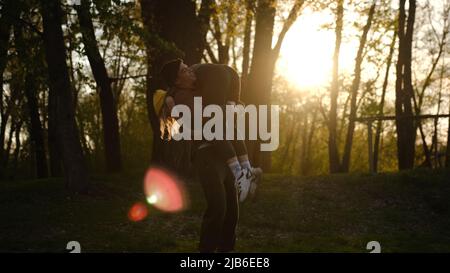 man and woman at sunset. A romantic date and love on nature of loving happy couple. Dancing and fooling couple in forest at sunset. Stock Photo