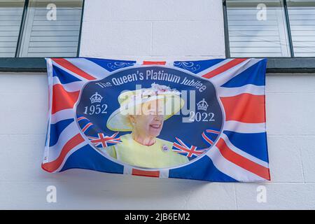 3 June 2022: Queen Elizabeth platinum jubilee flag, hanging from a house window, London Stock Photo