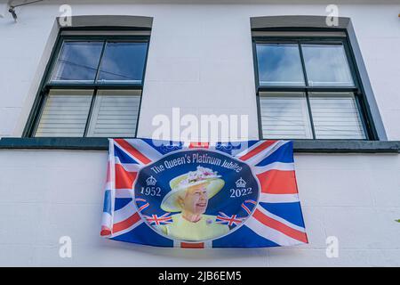 3 June 2022: Queen Elizabeth platinum jubilee flag, hanging from a house window, London Stock Photo