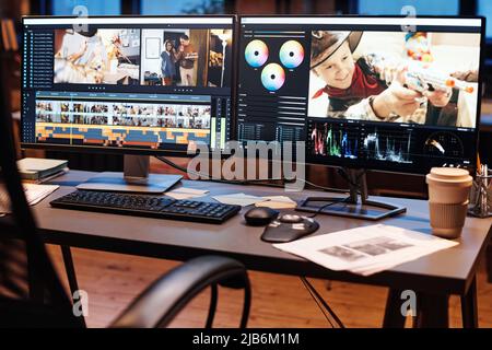 Image of table with computer with software for editing photos on monitor at office Stock Photo