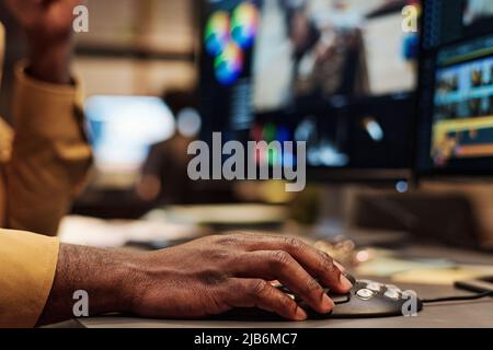 Close-up of African colorist using computer mouse for editing photos on computer at his workplace Stock Photo