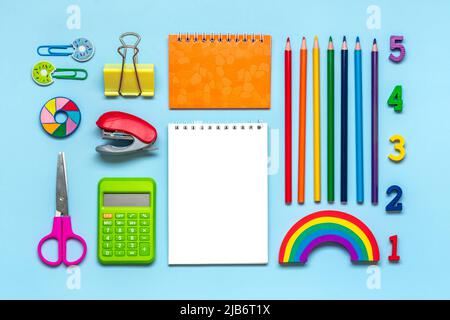Frame from school and office supplies Paper clips, pens, calculator, sharpener, notepad, stapler isolated on blue background Flat lay Top view Back to Stock Photo