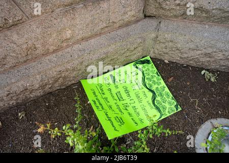 Austin Texas USA, May 30 2022: A protest sign lies near the Texas Capitol memorials honoring the 21 victims of the Uvalde, Texas school massacre on May 24. The handwritten sign reads '19 armed men were outside the Uvalde classroom yet 19 children and 2 adults die by an armed 18 year old with AR 15 assault weapon. Change gun laws! Create universal background checks!' Stock Photo