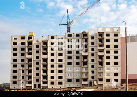 Construction of a residential building made of concrete blocks. View of the facade of an unfinished building. Stock Photo