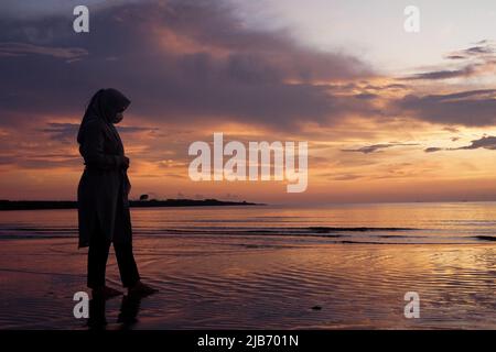 Makassar, South Sulawesi, Indonesia. 3rd June, 2022. A woman enjoying the atmosphere on the edge of Makassar's Bosowa Beach. This beach gets crowded on weekends by tourists to enjoy the beach view and sunset (Credit Image: © Herwin Bahar/ZUMA Press Wire) Stock Photo