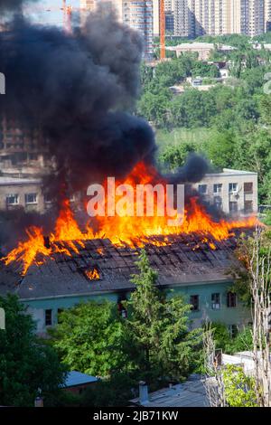 A fire in an old abandoned house, a view from the window of a neighboring high-rise building. Stock Photo