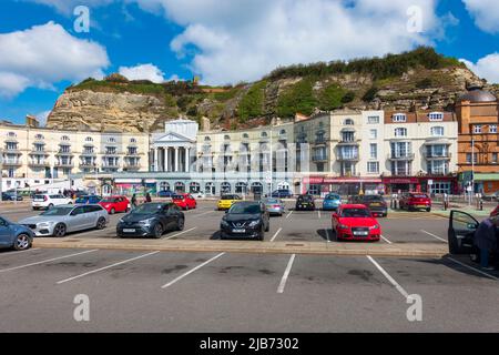 Hastings Castle dominates Pelham Crescent and Arcade viewed from the beach, Hastings, East Sussex, UK Stock Photo