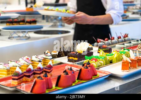 The waiter carries pastries and cakes to the hotel bar Stock Photo