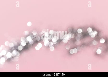 Sparkling silver glitter on pink background. Holiday blurred lights Stock Photo