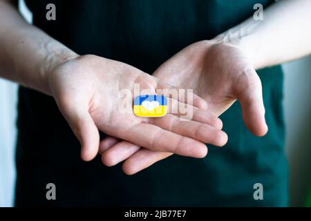 Support for Ukraine in the war with Russia. A young man holds a stylized flag of Ukraine. Conceptual photo. Stock Photo