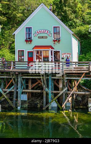 Ketchikan, Alaska, USA - July 17, 2011: Closeup of light green painted Dolly's Museum and gift shop built on stilts at mouth of Ketchikan creek. Green Stock Photo