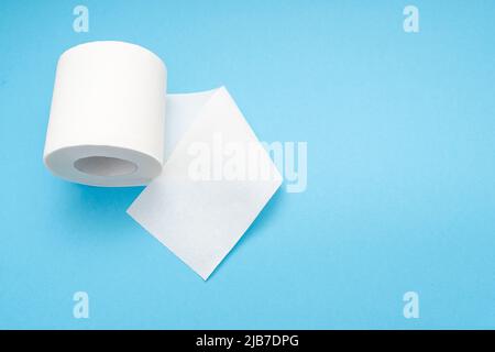 White blank roll of toilet paper with long sheet on blue background, top view Stock Photo