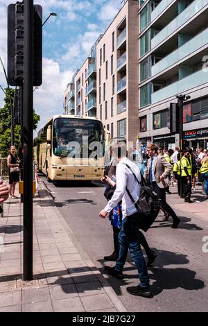 Epson Surrey, London UK, June 03 2022, People Crossing Road Infront Of A Public Transport Coach Stock Photo