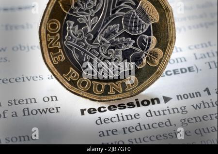 DICTIONARY DEFINITION OF WORD RECESSION WITH ONE POUND COIN RE THE COST OF LIVING CRUNCH CRISIS JOBS INCOMES INFLATION ETC UK Stock Photo