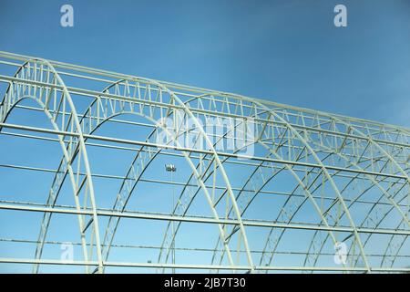 Basis for warehouse. Metal beams. Details of construction of sports complex. Steel details against blue sky. Stock Photo