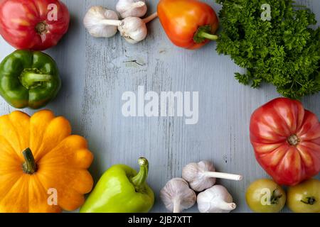Frame of ripe vegetables from the garden bed on a blue wooden background. Harvest festival Stock Photo