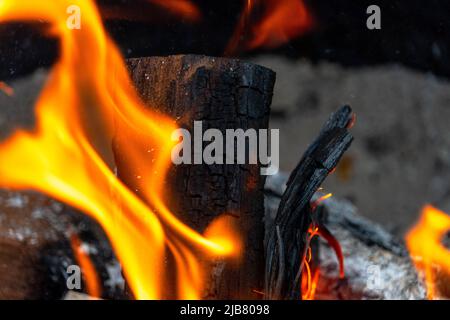 Bright and massive orange flames from a mesquite log in a fire pit. Stock Photo