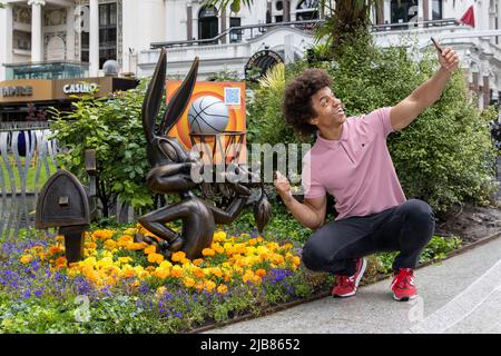 To celebrate the release of Space Jam: A New Legacy, the Bugs Bunny statue in Leicester Square is being upgraded with interactive basketball hoop and stunning floral design. The iconic bunny will be joined for the day by a basketball challenge, as young basketball stars of the future in Space Jam kits perform dribbling and shooting tricks and challenges Featuring: Radzi Chinyanganya Where: London, United Kingdom When: 06 Jul 2021 Credit: Phil Lewis/WENN Stock Photo