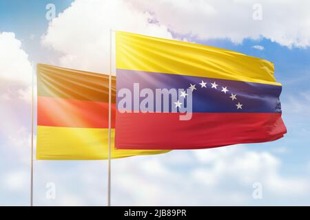 Sunny blue sky and flags of venezuela and germany Stock Photo