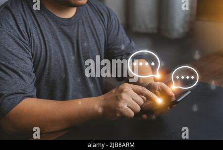 Close-up Men hands using mobile phone with chat icons. Man use smartphone chatting application and social network app. Social media application chat b Stock Photo