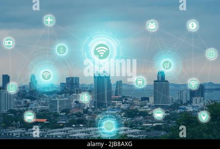 Modern Smart city communication network with graphic showing concept of internet of things (IOT). Virtual Icons of wifi, internet, communication, trav Stock Photo