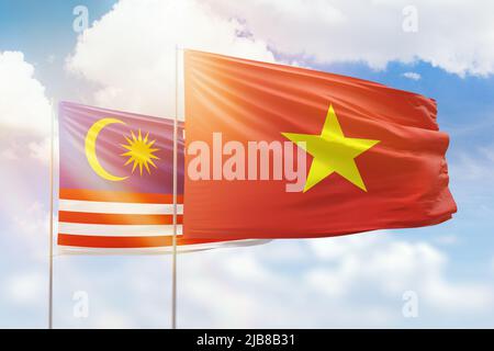 Sunny blue sky and flags of vietnam and malaysia Stock Photo