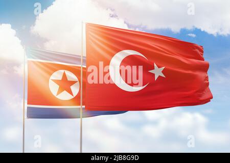 Sunny blue sky and flags of turkey and north korea Stock Photo