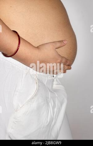 young pregnant women showing her round belly womb with hand from different angle Stock Photo
