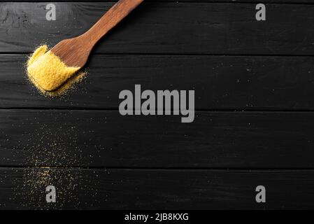 raw Italian corn porridge polenta on a dark stone background. Copy space and empty space for the text Stock Photo