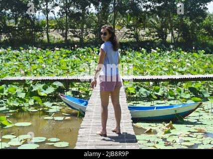 Young woman against Lotus lake in Vietnam Stock Photo