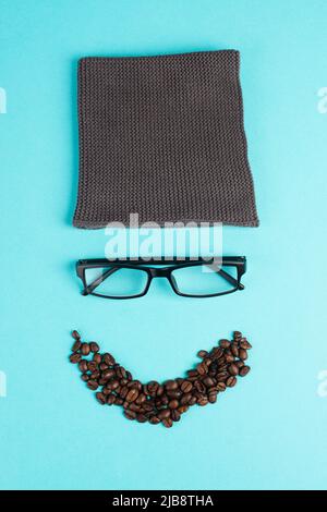 Human face made with a wool hat, glasses and coffee beans as a beard, funny minimalist portrait, eco freak lifestyle, having breakfast, taking a break Stock Photo