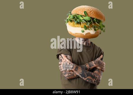 Tattooed man with tasty burger instead of his head on color background Stock Photo