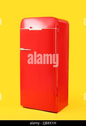 Stylish retro fridge on yellow background Stock Photo